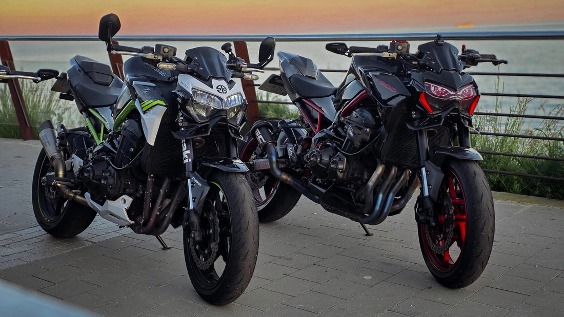 Dos Kawasaki Z900 de distinta generación aparcadas frente al mar al atardecer