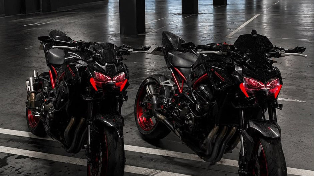 Dos Kawasaki Z900 negras y rojas aparcadas en un garaje, vistas de lado