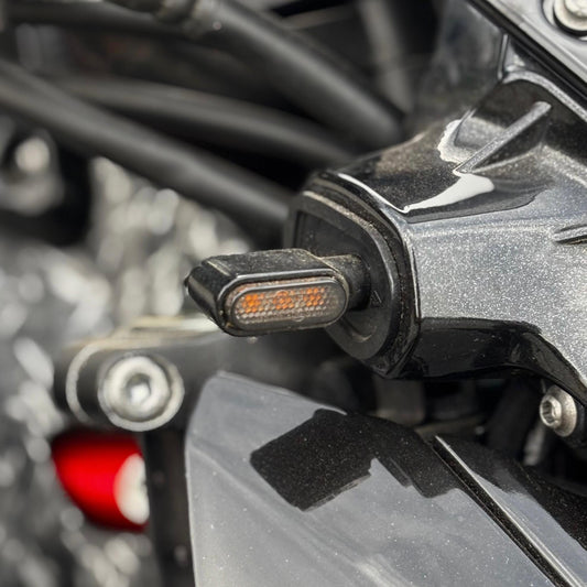Mini intermitente LED ahumado montado en el manillar de una Kawasaki Z900