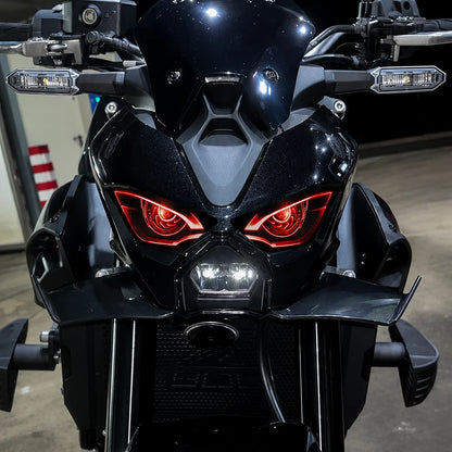 Kawasaki Z900 2025 de noche con el vinilo de faro delantero de ojos rojos puesto