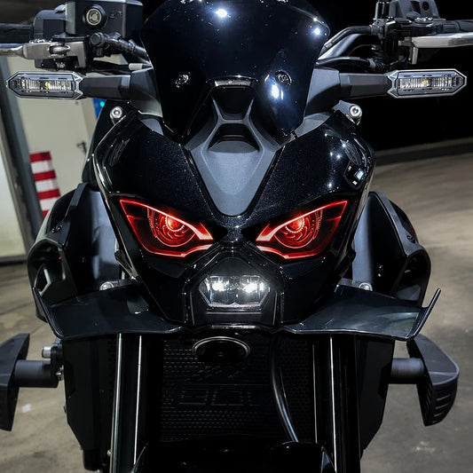 Kawasaki Z900 2025 de noche con el vinilo de faro delantero de ojos rojos puesto