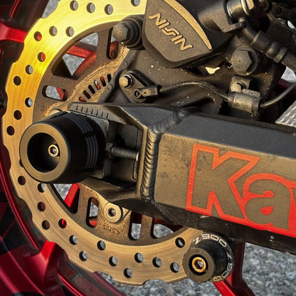 Protector de eje trasero con grabado 900 montado en el basculante de nuestra Kawasaki Z900, incluido en el kit
